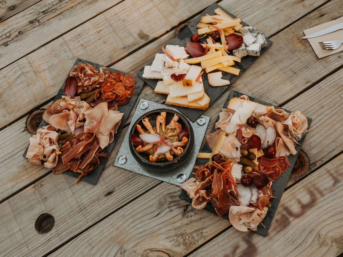 Planches de charcuterie, fromages et crevettes à partager sur les tables en bois de L’Espagnette
