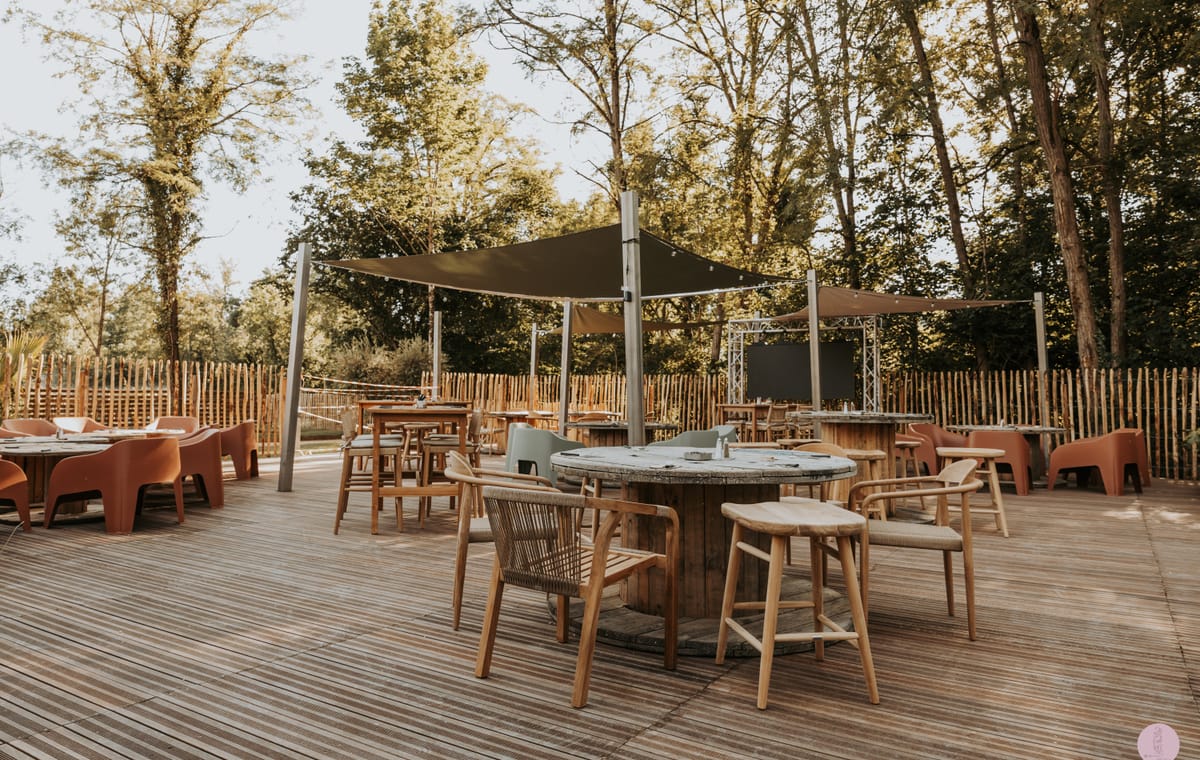 La terrasse en bois de L'Espagnette avec écran géant et mange-debout, prête pour les soirées et les retransmissions